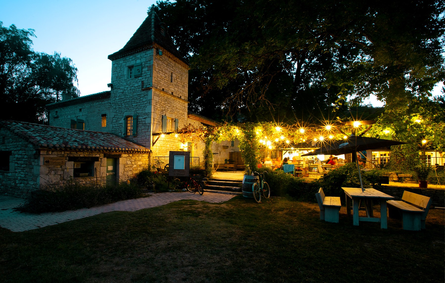Le pigeonnier en pierre du Domaine Saint Martial, à la tombée du jour, sous les guirlandes lumineuses.