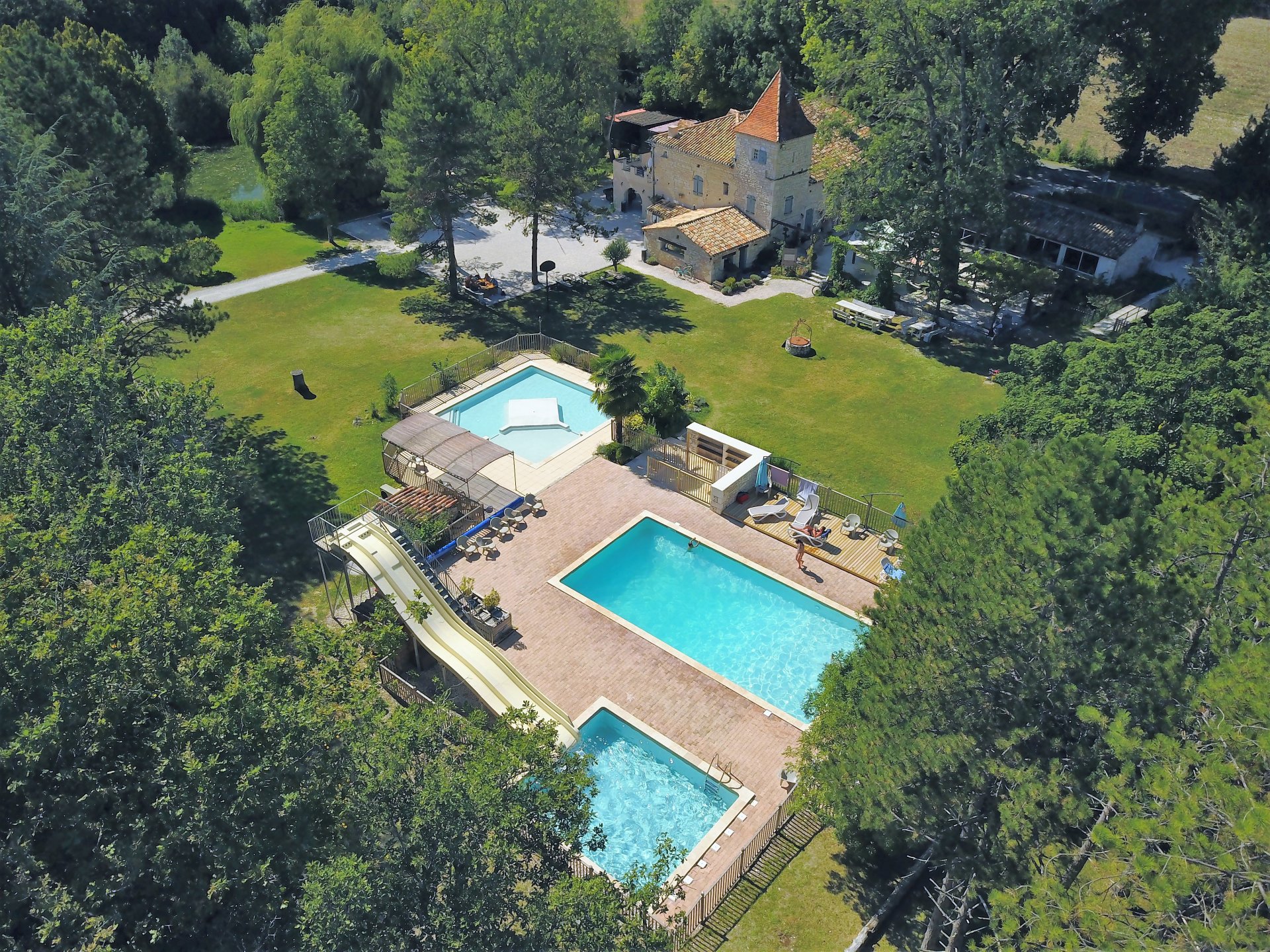 Vue aérienne de l’espace aquatique du Domaine Saint Martial, avec la piscine, les toboggans et la pataugeoire.